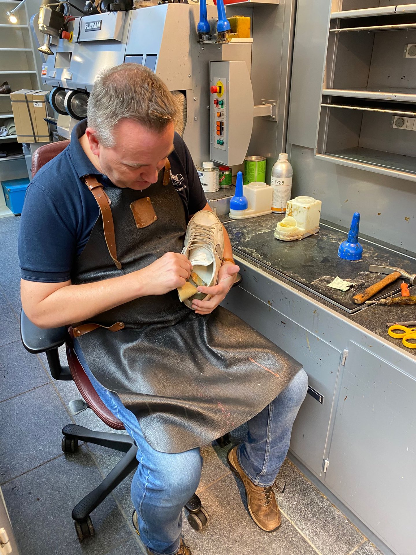 Schoenmaker aan het werk in het atelier